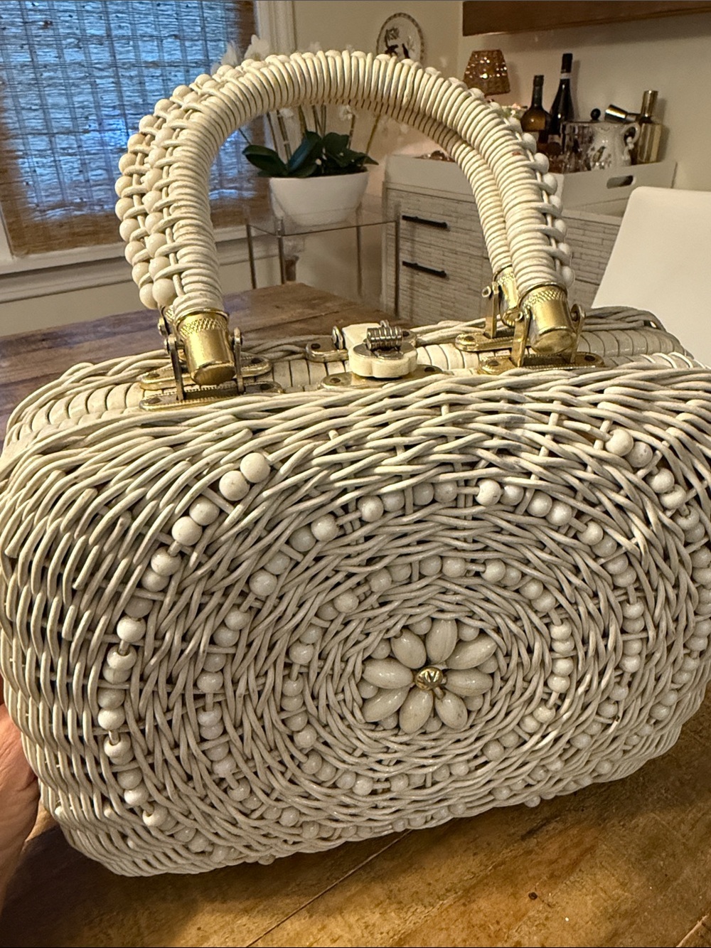 A vintage wicker bag with beaded design and mother-of-pearl hardware.